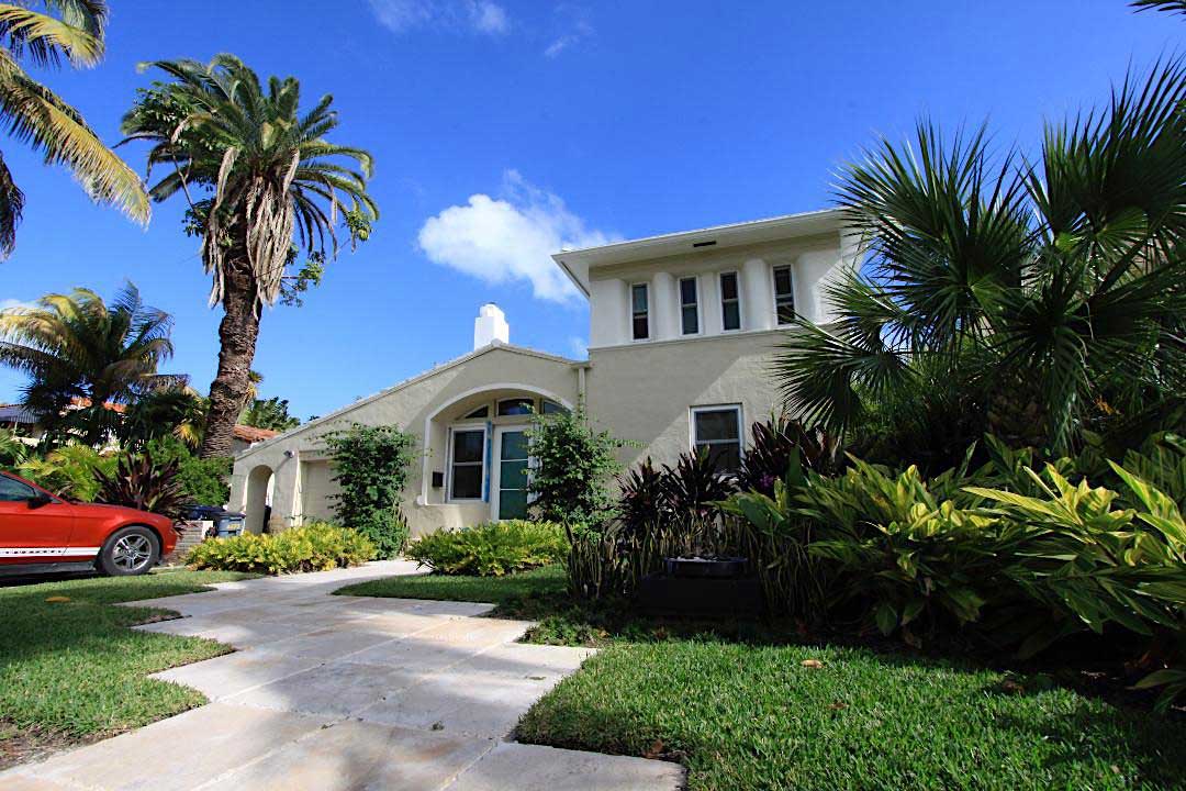 beige 2 story house built in Florida with Palm Trees